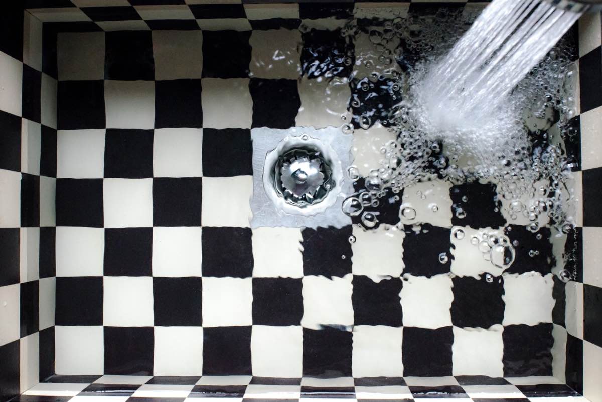Water in a sink with checkerboard tile