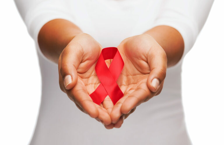 National Black HIV/AIDS Awareness Day: Hands holding a red AIDS awareness ribbon